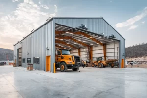 Government steel building public works garage with trucks and loaders inside open bays